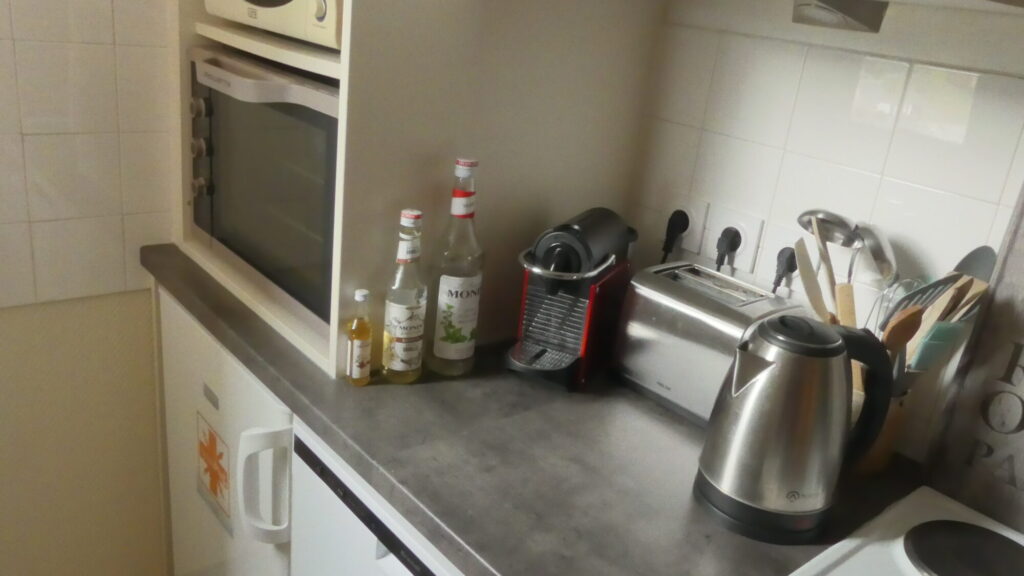 Cuisine équipée avec cafetière, grille-pain, bouilloire, four, micro-ondes, frigo...